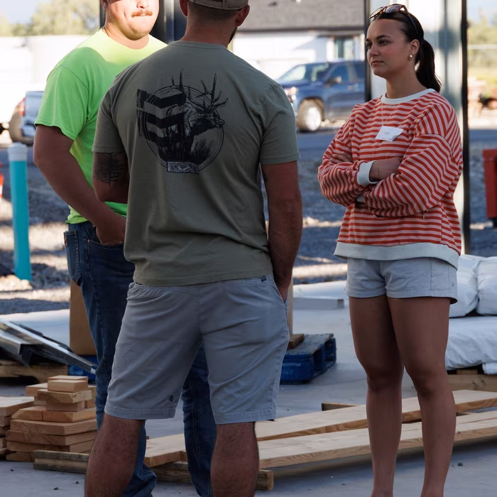 Church members talking near stacks of framing lumber