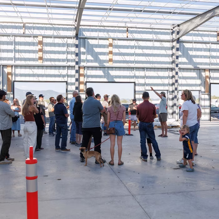 Congregation gathered inside the open building frame with mountain views